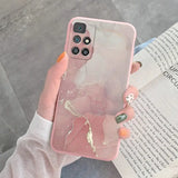 a woman holding a pink iphone case with gold glitter