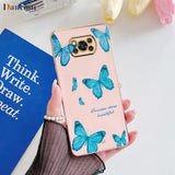 a woman holding a pink phone case with blue butterflies on it