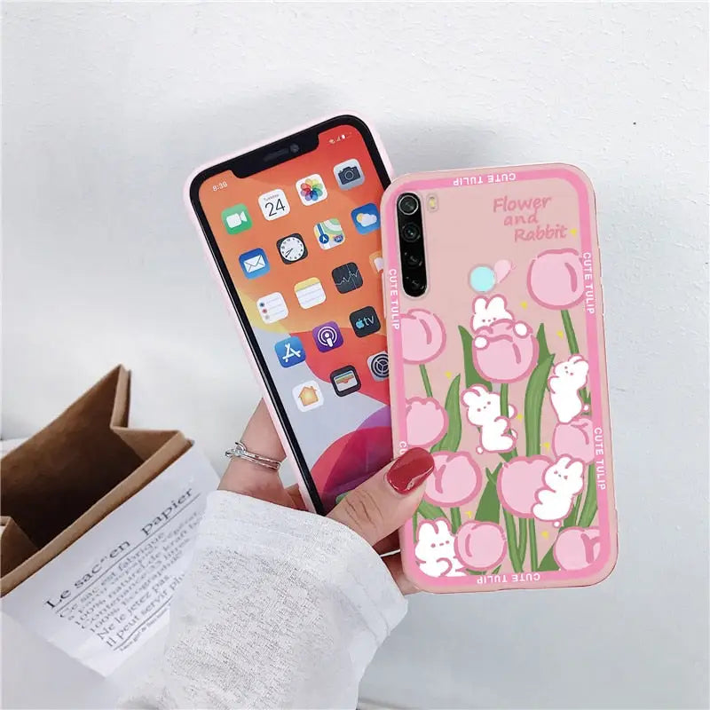 a person holding a pink phone case with flowers