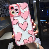 a girl holding up a pink phone case with hearts