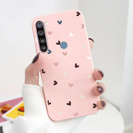 a woman holding a pink phone case with hearts on it