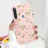 a woman holding a pink phone case with white flowers on it