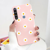 a woman holding a pink phone case with daisies on it