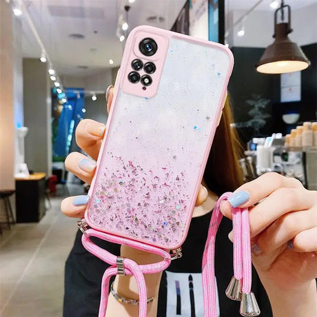 someone holding a pink phone case with a pink strap