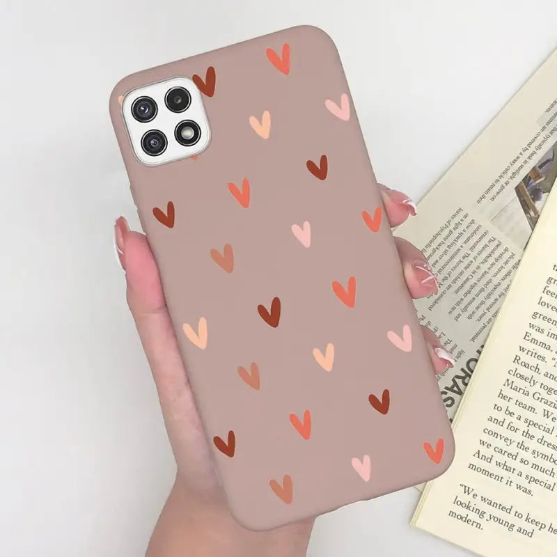 a woman holding a phone case with hearts on it