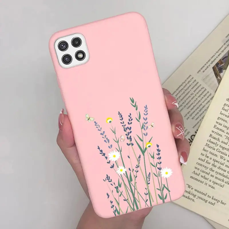 a woman holding a pink phone case with flowers
