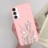 a woman holding a pink phone case with flowers on it