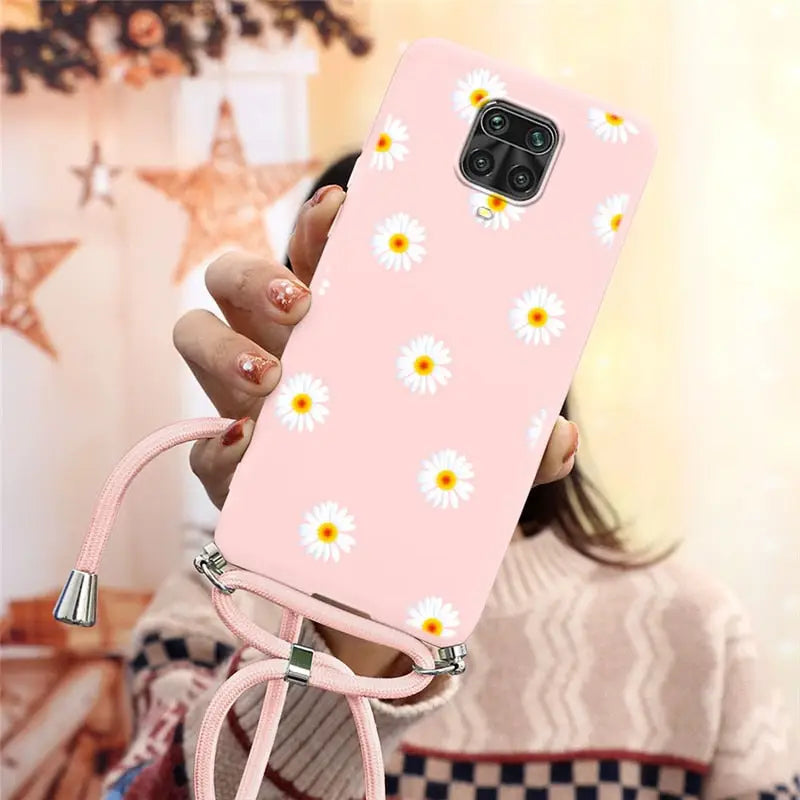 there is a woman holding a pink phone case with daisies on it