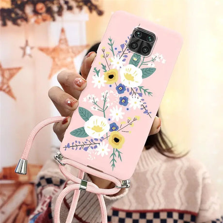 a woman holding a pink phone case with flowers on it