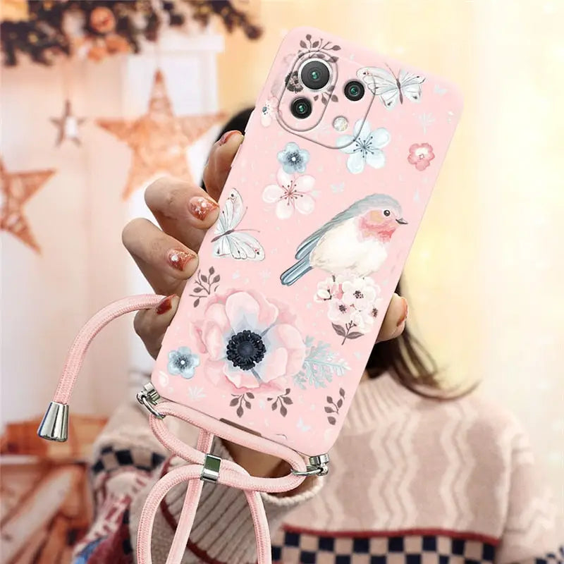 a girl holding a pink phone case with flowers and birds