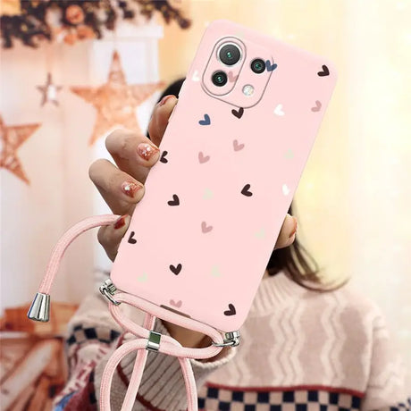 a girl holding a pink phone case with hearts on it