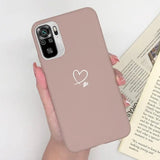 a woman holding a pink phone case with a heart on it