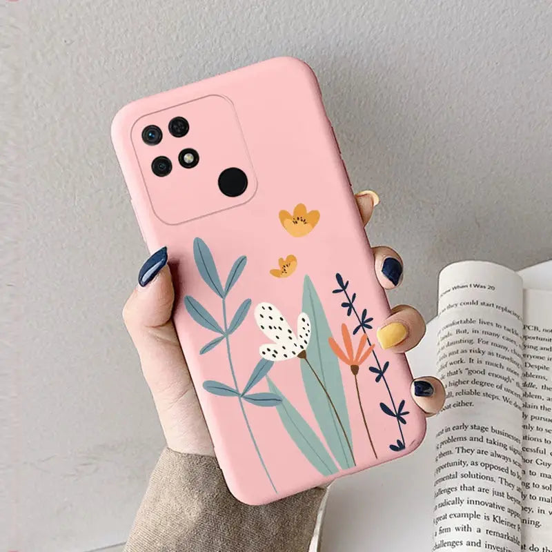 a woman holding a pink phone case with flowers on it