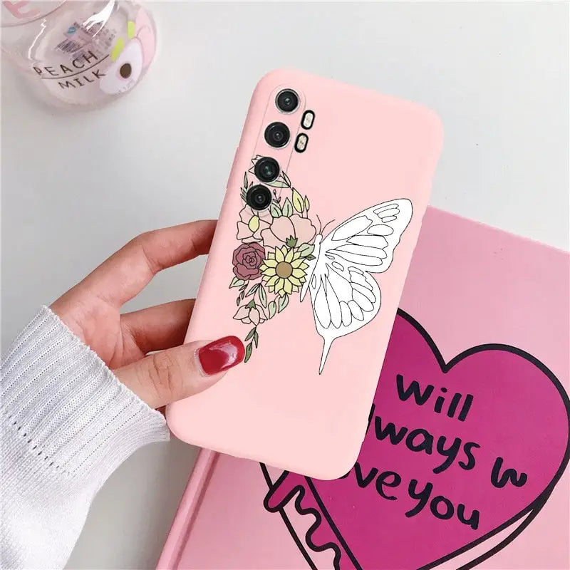 a woman holding a pink phone case with a flower and butterfly