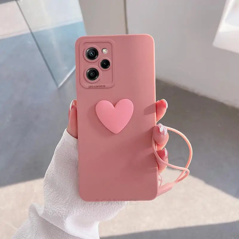 a woman holding a pink phone case with a heart on it