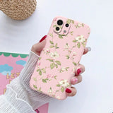 a woman holding a pink phone case with flowers on it