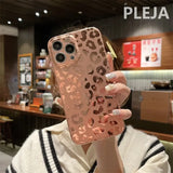 a woman holding up a phone case with a leopard print