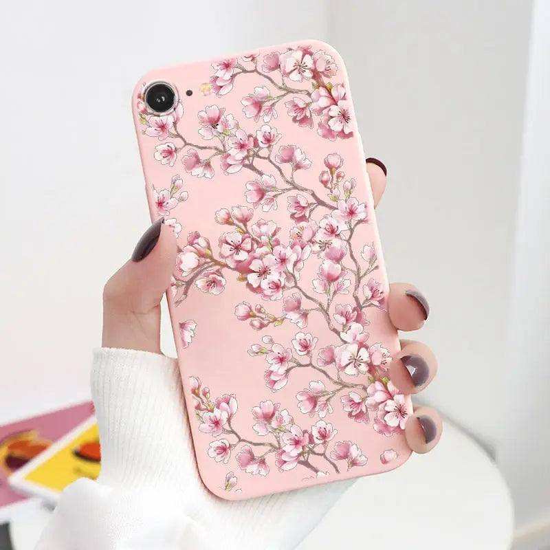 a woman holding a pink phone case with a pink flower design