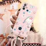 a woman holding a pink phone case with flowers and birds