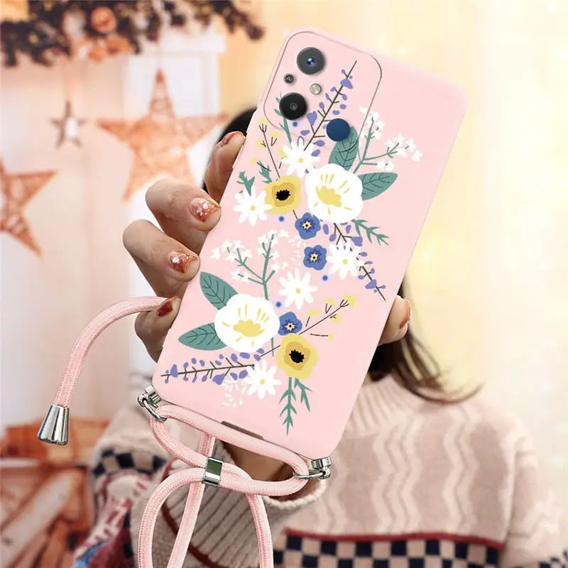 a woman holding a pink phone case with flowers on it