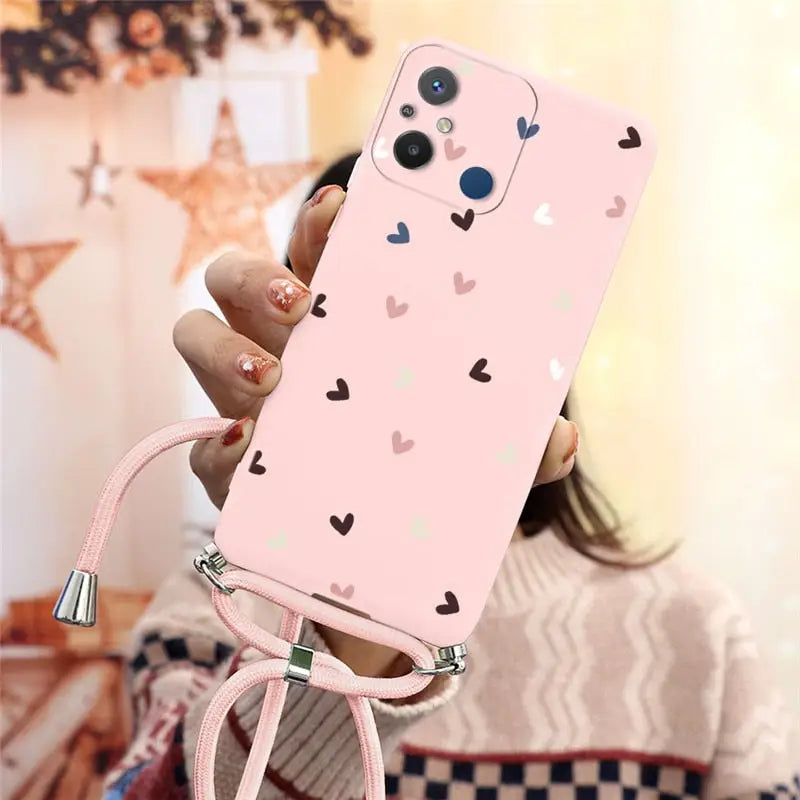 a woman holding a pink phone case with hearts on it