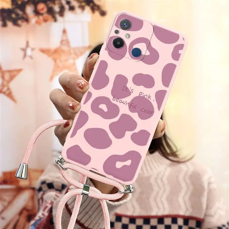 a woman holding a pink phone case with a pink leopard print