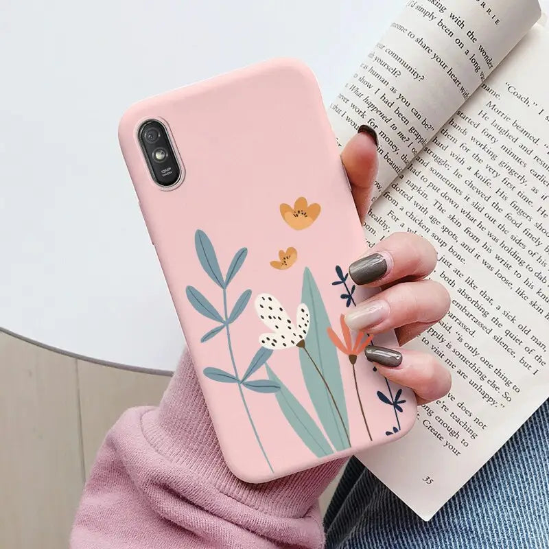 a woman holding a pink phone case with a flower design