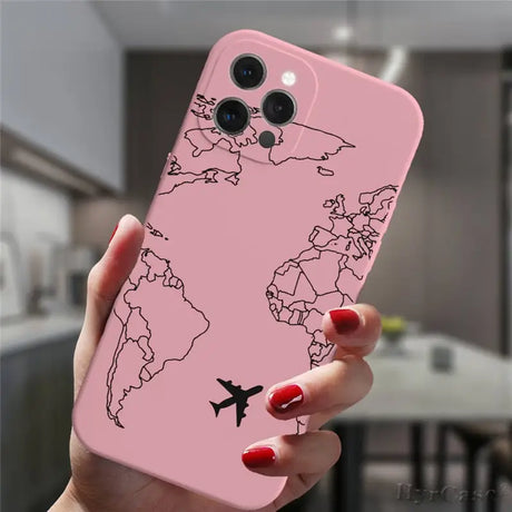 a woman holding a pink phone case with a world map on it