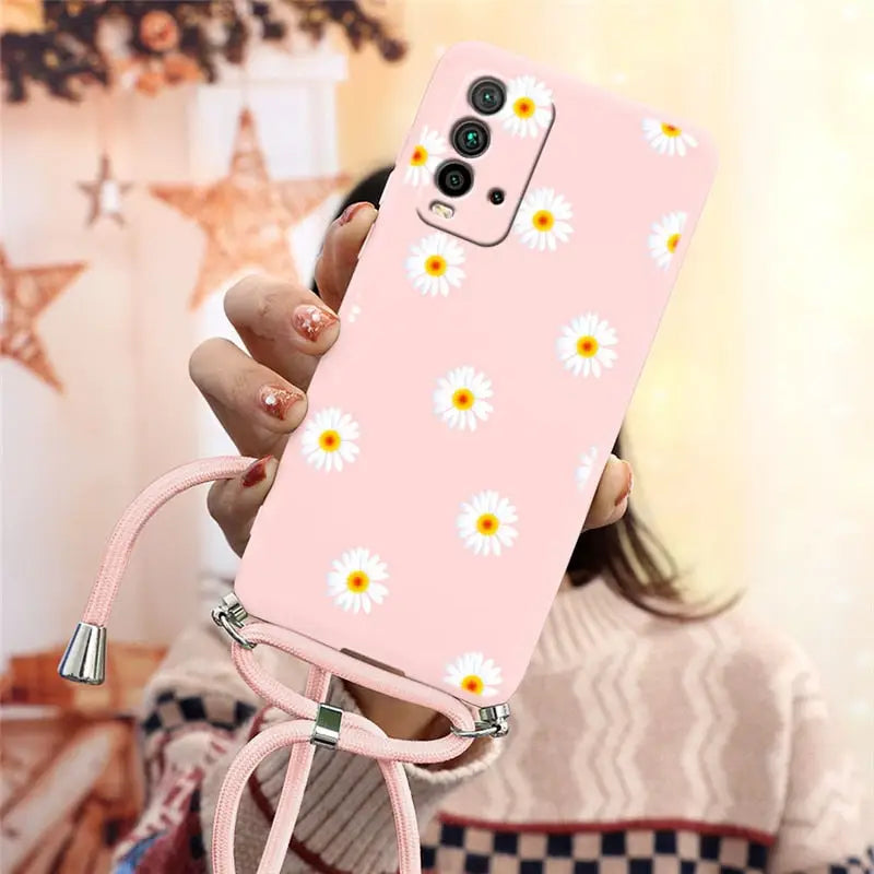 someone holding a pink phone case with daisies on it