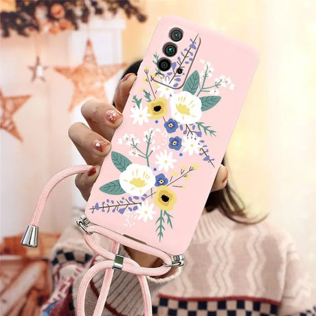 a woman holding a pink phone case with flowers on it