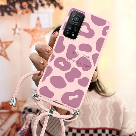 a woman holding a pink phone case with a pink leopard print