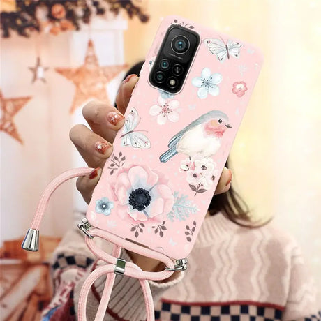 a woman holding a pink phone case with flowers and birds