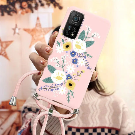 a woman holding a pink phone case with flowers on it