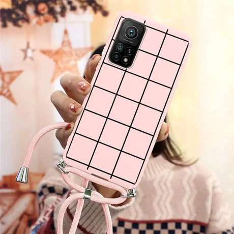 a woman holding a pink phone case with a grid pattern