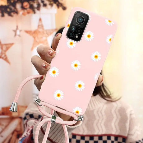 someone holding a pink phone case with daisies on it