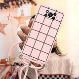 a woman holding a pink phone case with a grid pattern