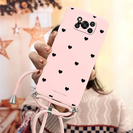 a woman holding a pink phone case with hearts on it