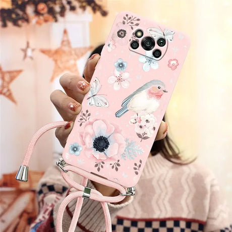 a woman holding a pink phone case with flowers and birds