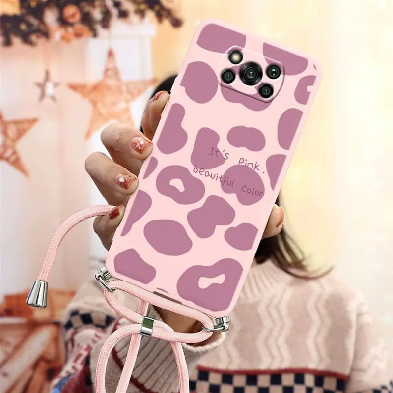 a woman holding a pink phone case with a pink cam pattern