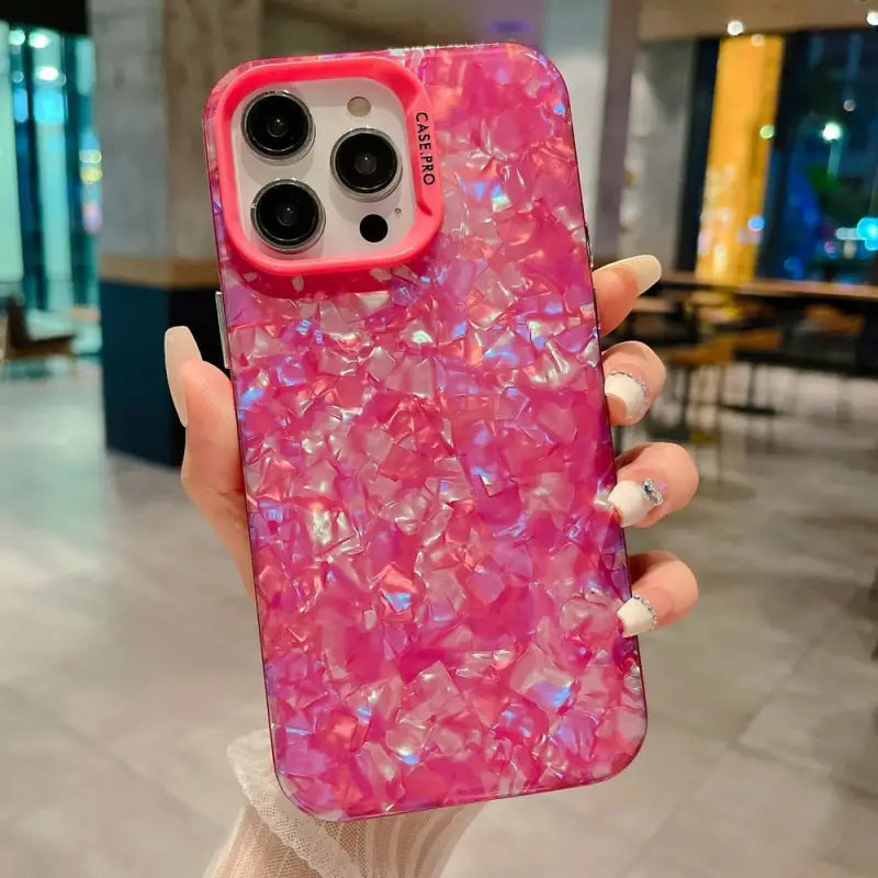 a woman holding a pink phone case with pink marble