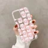 a woman holding a pink phone case with a pattern of pink and white flowers