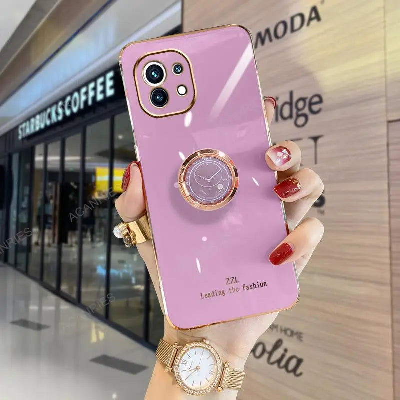 a woman holding a pink phone case with a watch on it
