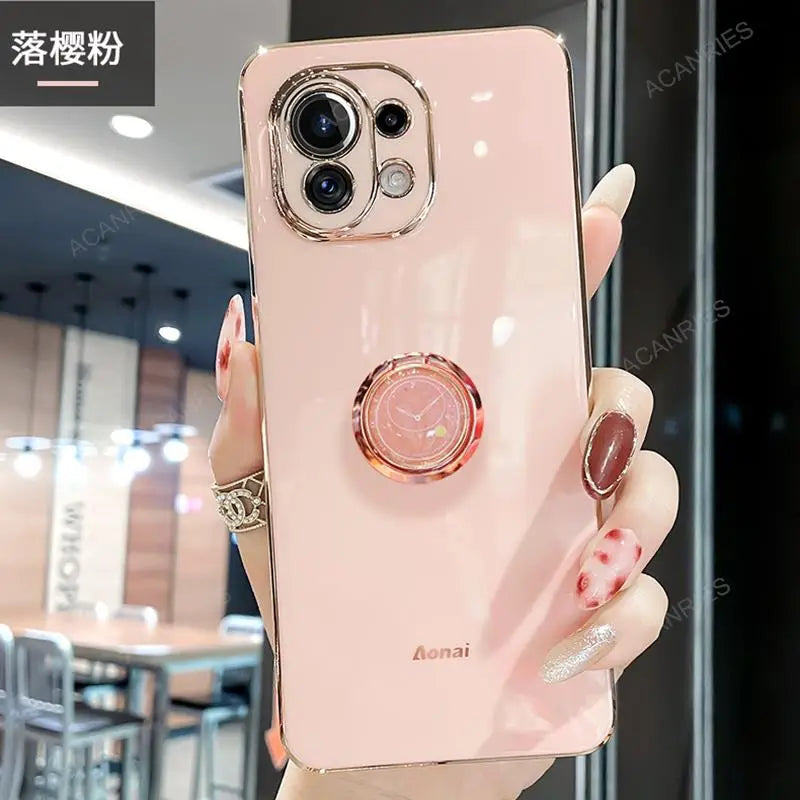 a woman holding a pink phone case with a ring on it