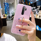 a woman holding a phone case with pink glitter