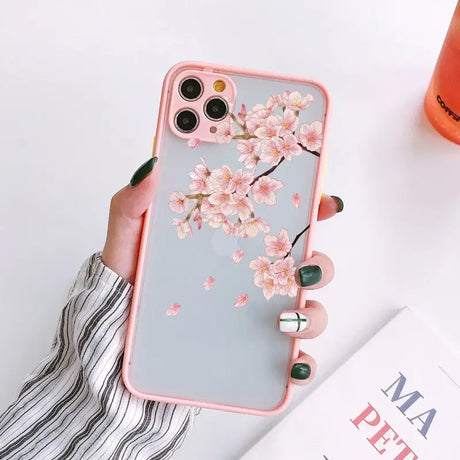 a woman holding a pink phone case with a flower on it