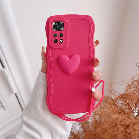 a woman holding a pink phone case with a heart on it