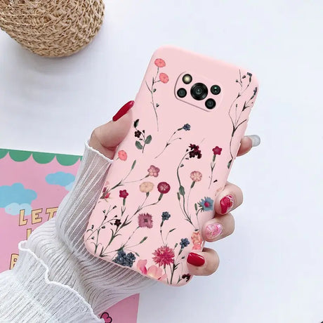 a woman holding a pink phone case with flowers on it