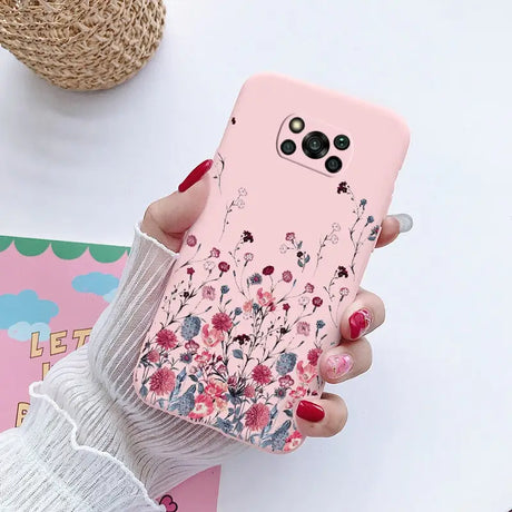 a woman holding a pink phone case with flowers on it