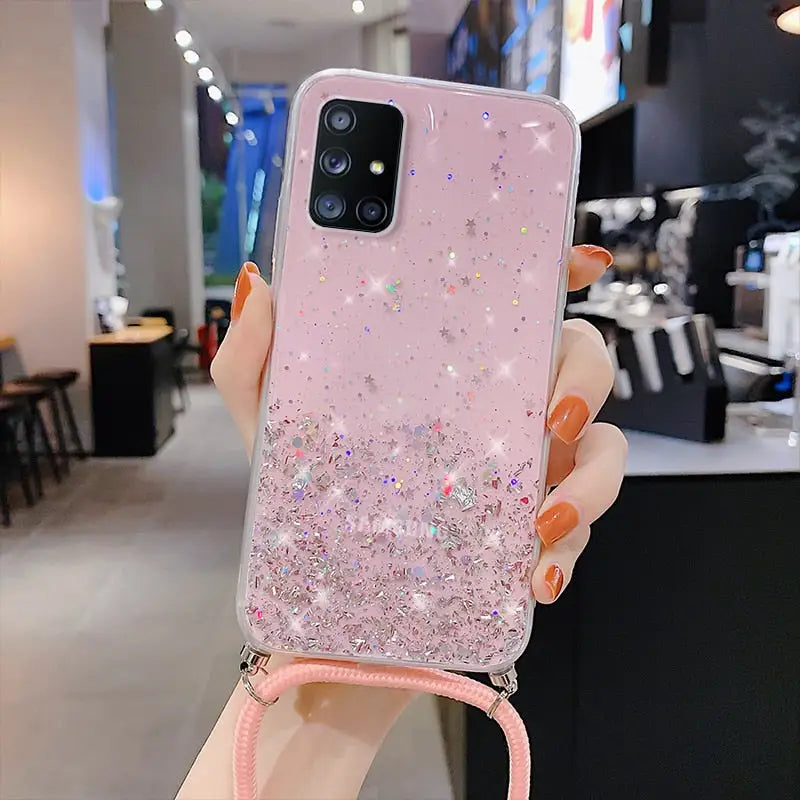 a woman holding up a pink phone case with glitter