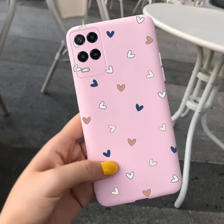 a woman holding a pink phone case with hearts on it